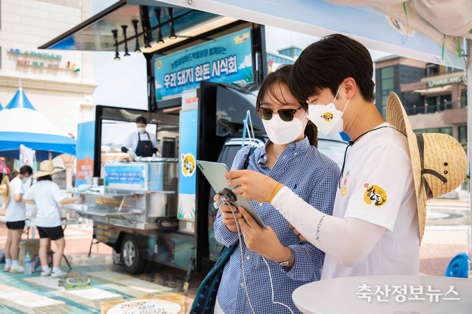 ‘2022 보령해양머드박람회, 다 함께 한돈!’ 행사장을 찾은 관광객이 한돈 퀴즈를 풀고 있다.