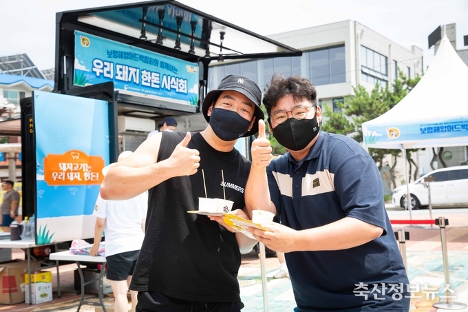 피서객들이 한돈 메뉴와 함께 포즈를 취하고 있다.