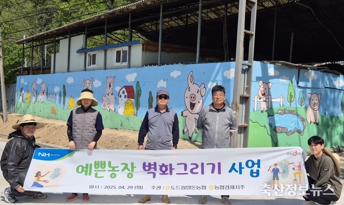 도드람양돈농협 조합원 아람농장 김춘일 대표(왼쪽에서 세번째)를 비롯한 임직원들이 ‘예쁜 농장 벽화 그리기’ 행사를 마친 후 기념사진을 촬영하고 있다.